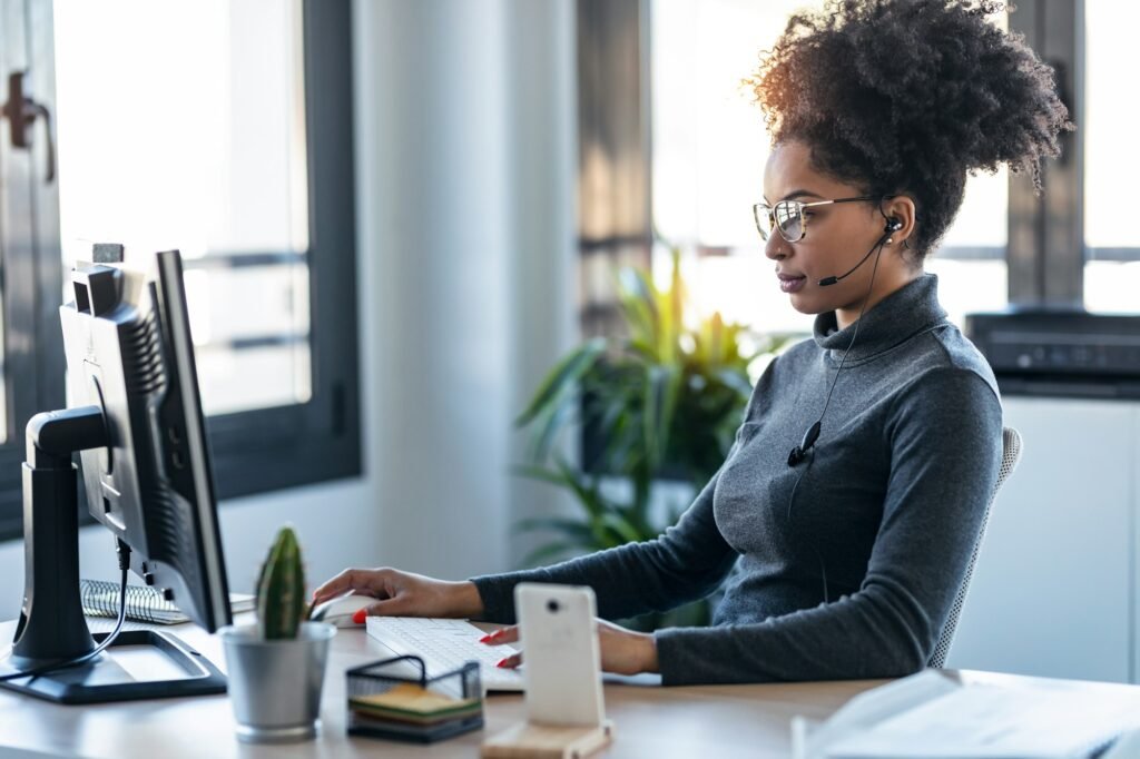 Afro business woman working while making video call with computer sitting in the office.